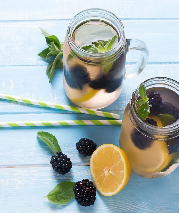 Blackberry and lemon infused water in mason jars